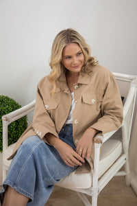 Sitting down wearing the Audrey Trench Coat in Desert Camel